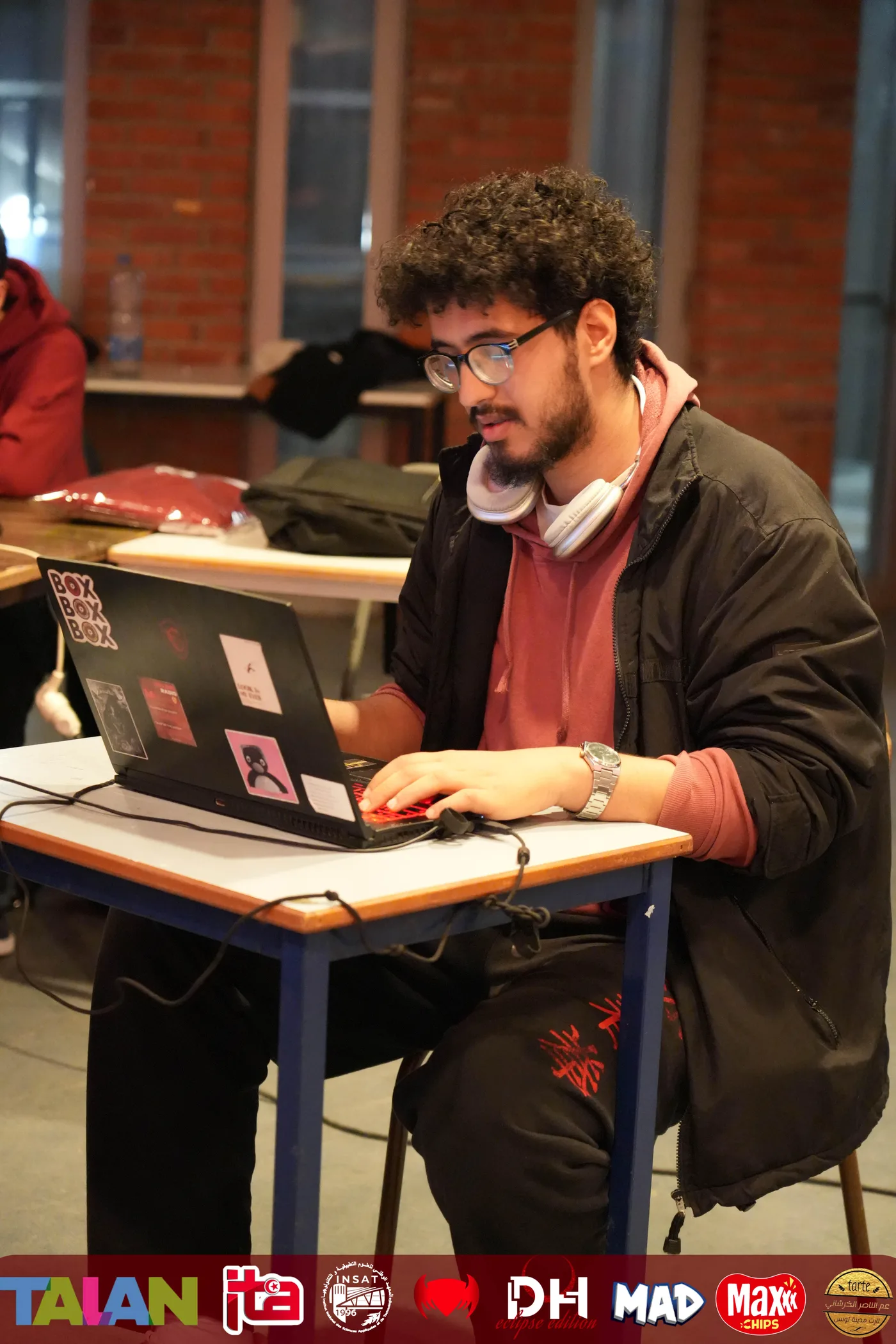 Ghaith Amdouni working on his laptop at a technology event